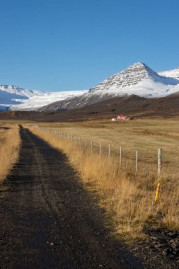 Sonbaharda dağın tepesine kar yağacak. Geriye kalan tüm topraklar yok olacak. Parlak mavi gökyüzü. Neskaupstadur 'a yakın bir yer, Doğu İzlanda.