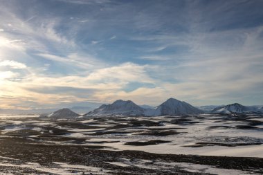 Gayzerlerin çok sık görüldüğü ve jeotermal aktivitelerin kar üzerindeki çözülmemiş çizgilerde de görülebildiği bölge. Kuzey-Merkez Bölgesi Myvatn, İzlanda 'da gün batımı.