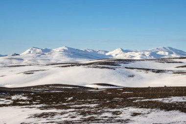 Gayzerlerin çok sık görüldüğü ve jeotermal aktivitelerin kar üzerindeki çözülmemiş çizgilerde de görülebildiği bölge. Kuzey-Merkez Bölgesi Myvatn, İzlanda 'da gün batımı.