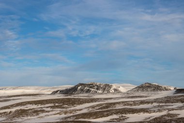Gayzerlerin çok sık görüldüğü ve jeotermal aktivitelerin kar üzerindeki çözülmemiş çizgilerde de görülebildiği bölge. Kuzey-Merkez Bölgesi Myvatn, İzlanda 'da gün batımı.