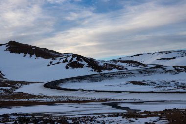 Gayzerlerin çok sık görüldüğü ve jeotermal aktivitelerin kar üzerindeki çözülmemiş çizgilerde de görülebildiği bölge. Kuzey-Merkez Bölgesi Myvatn, İzlanda 'da gün batımı.