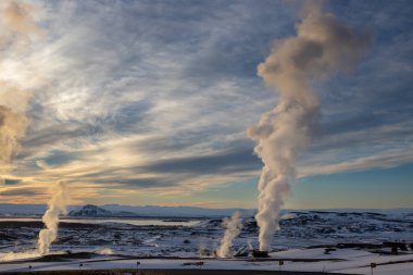 Gayzerlerin çok sık görüldüğü ve jeotermal aktivitelerin kar üzerindeki çözülmemiş çizgilerde de görülebildiği bölge. Kuzey-Merkez Bölgesi Myvatn, İzlanda 'da gün batımı.