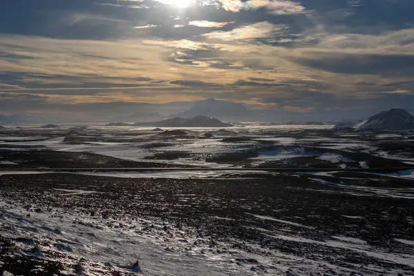 Gayzerlerin çok sık görüldüğü ve jeotermal aktivitelerin kar üzerindeki çözülmemiş çizgilerde de görülebildiği bölge. Kuzey-Merkez Bölgesi Myvatn, İzlanda 'da gün batımı.