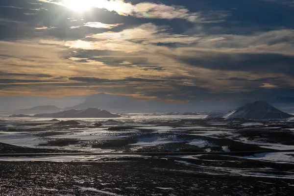 Gayzerlerin çok sık görüldüğü ve jeotermal aktivitelerin kar üzerindeki çözülmemiş çizgilerde de görülebildiği bölge. Kuzey-Merkez Bölgesi Myvatn, İzlanda 'da gün batımı.