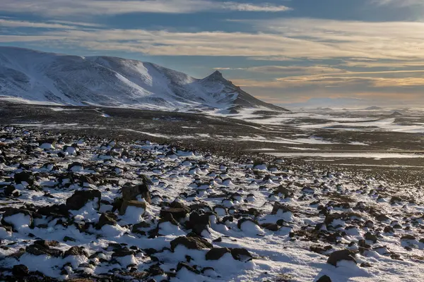 Gayzerlerin çok sık görüldüğü ve jeotermal aktivitelerin kar üzerindeki çözülmemiş çizgilerde de görülebildiği bölge. Kuzey-Merkez Bölgesi Myvatn, İzlanda 'da gün batımı.