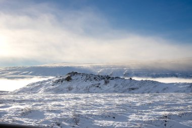 Kuzey Kutbu kışı sonbaharda başladı ve karla kaplandı. Çünkü şelale havası buhar ve sisle doludur, kısmen arka plandaki dağları gizler. Fossholl - Godafoss, İzlanda.
