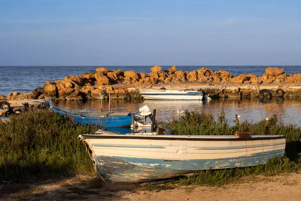 Akdeniz adasının batısındaki küçük bir köyde sakin bir sabah. Kayalardan yapılmış küçük bir liman. Renkli tekneler. Spiaggia Sibiliana, Marsala, Sicilya, İtalya.