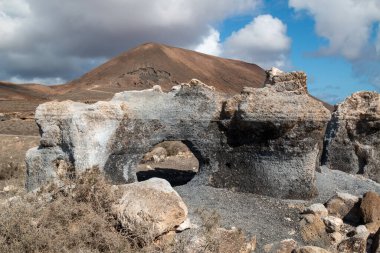 Erime sonucu oluşan çeşitli kaya oluşumlarıyla doğal park. Stratified City olarak da bilinir. Kışın beyaz bulutlu mavi gökyüzü. Teseguite, Lanzarote, Kanarya Adaları, İspanya.