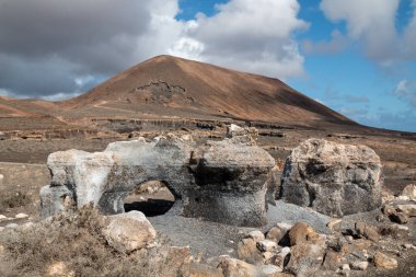 Erime sonucu oluşan çeşitli kaya oluşumlarıyla doğal park. Stratified City olarak da bilinir. Kışın beyaz bulutlu mavi gökyüzü. Teseguite, Lanzarote, Kanarya Adaları, İspanya.