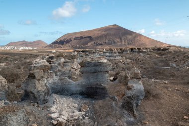 Natural park with various rock formations created by erosion. Called also Stratified City. Blue sky with white clouds in the winter. Teseguite, Lanzarote, Canary Islands, Spain. clipart