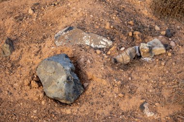 Kumlu toprağın turuncu rengi, çakıl ve daha büyük taşlarla dolu. Kuru ve ıssız topraklar. Lanzarote, Kanarya Adaları, İspanya.