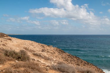 Atlantik Okyanusu kıyısındaki volkanik kayalar. Kışın bulutlu bir gökyüzü. Arrieta, Lanzarote, Kanarya Adaları, İspanya.