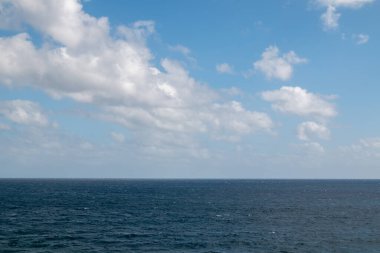Atlantik okyanusunun sakin suları. Kışın bulutlu bir gökyüzü. Arrieta, Lanzarote, Kanarya Adaları, İspanya.