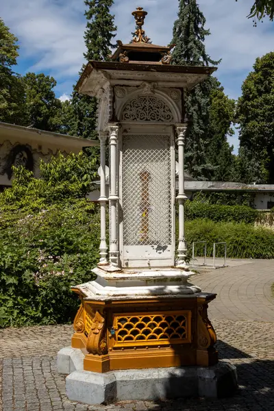 stock image Meteorological column in style of art noveau, located in the park of Spa Island. Bright sunshine and fresh greenery. Blue sky with white clouds. Piestany, Slovakia.