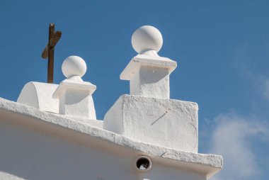 Binanın ön cephesinin geleneksel beyaz rengi. Üzerinde haç olan küçük kilisenin detayları. Masdache, Lanzarote, Kanarya Adaları, İspanya.