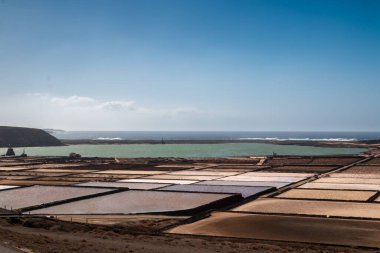 Atlantik Okyanusu 'nun doğal lagününden gelen sular tuz üretmek için buharlaşır. Mavi gökyüzü. Salinas del Janubio, Lanzarote, Kanarya Adaları, İspanya