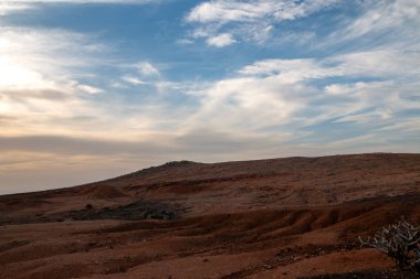 Atlantik okyanusunun sakin suları. Kışın bulutlu bir gökyüzü. Renkli bulutlarla gün batımı. Bakış açısı Miarador del Rio, Lanzarote, Kanarya Adaları, İspanya.