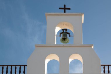 Geleneksel beyaz yüzlü bir bina. Bir çanlı ve tepesinde haç olan bir çan kulesi olan kilise. Kışın açık beyaz bulutlu mavi gökyüzü. Ye, Lanzarote, Kanarya Adaları, İspanya.