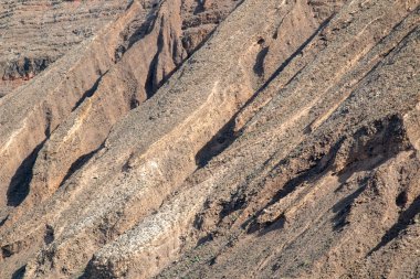 Adanın kuzeyindeki kayalıklardan ve volkanik kayalıklardan bir tekne görüntüsü. Kışın beyaz bulutlu mavi gökyüzü. Mirador del Rio, Lanzarote, Kanarya Adaları, İspanya.
