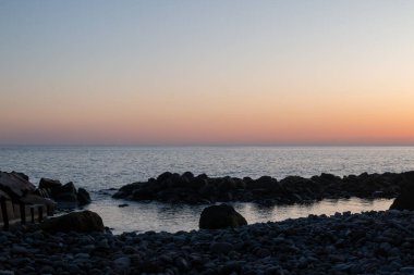 Atlantik Okyanusu kıyılarında bir sürü karanlık taş ve kaya var. Doğal bir havuz yaratıyorlar. Altın saat boyunca rengarenk gökyüzü. Paul do Mar, Madeira, Portekiz.