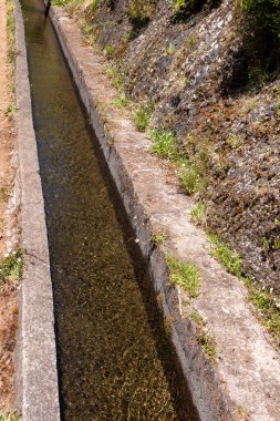 Su kanalının ayrıntıları - levada, dağlardan gelen temiz ve doğal bir su ile. Parlak güneşli bir gün. Levada das 25 fontes Rabacal, Paul da Serra, Madeira, Portekiz.