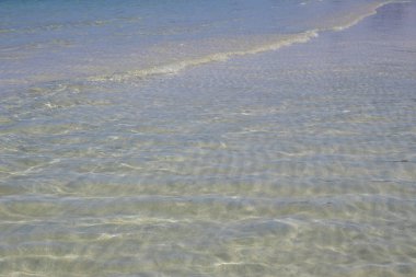 Kumlu dipli sığ deniz suyu. Yansımalar ve çok nazik dalgalar. Djerba, Tunus 'ta Akdeniz.