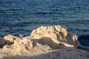 Akdeniz 'in kayalık kıyıları. Sahilin umumi bir parçası. Altın saatin ışığında kayalar. Djerba, Tunus, Afrika.