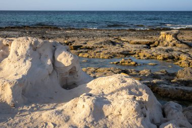 Akdeniz 'in kayalık kıyıları. Sahilin umumi bir parçası. Altın saatin ışığında kayalar. Djerba, Tunus, Afrika.