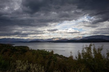 İyonik denizin sakin suları. Arnavutluk 'un dağlarındaki Yunan adasından görüntü. Yazın sonunda yoğun bulutlarla dolu bir gökyüzü. Kuzey Doğu Korfu, Yunanistan.