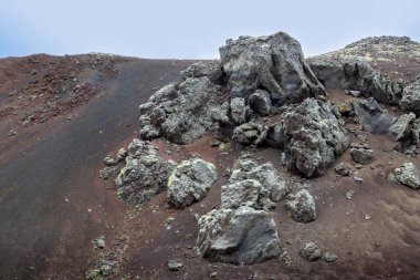 Tepenin kenarındaki kayaların soyut şekilleri. Arka planda bulutlu bir gökyüzü. Snaefellsnes Yarımadası, İzlanda.