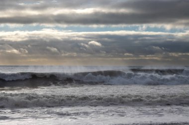 Atlantik 'in büyük dalgaları... Arka planda Horizon var. Sonbaharda bulutlu bir gökyüzü. Vikurfjara, Vik, İzlanda.