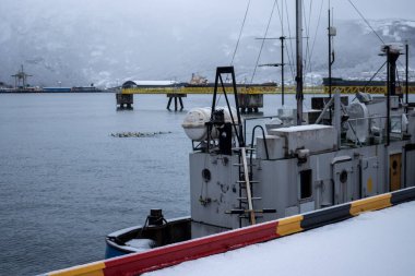 Limanda kar yağışlı bir kış günü. Taze karla kaplı rıhtımlar. Norveç, Narvik Limanı.