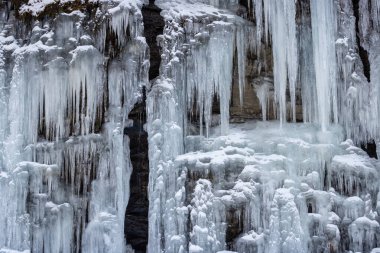 Dışarıdaki taş duvardan sarkan doğal buz saçakları. Grovfjord, Norveç Bölgesi.