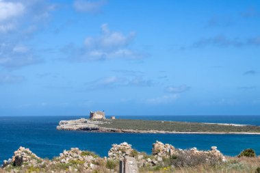 Historical fortress on an island Capopassssero (Isola di Capopassero). Bright water of the Mediterranean sea. Blue sky with white clouds. Forte di Capopassero, Sicily, Italy. clipart