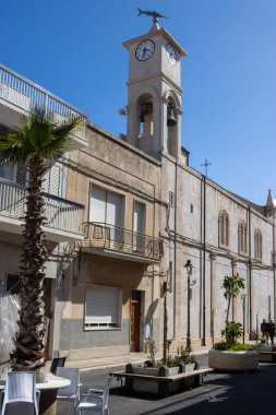 Aziz Gaetano Kilisesi 'nin çan kulesi. Kulenin tepesinde ve saatli kılıç balığı var. Mavi bahar gökyüzü. Portopalo, Sicilya, İtalya.