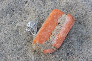 Eski bir tuğlanın güzelliği, gel-git sırasında denizden çıkarılmış. Denizin gücünün yuvarlak kenarları. Tyrhenian Sahili, Sicilya, İtalya.