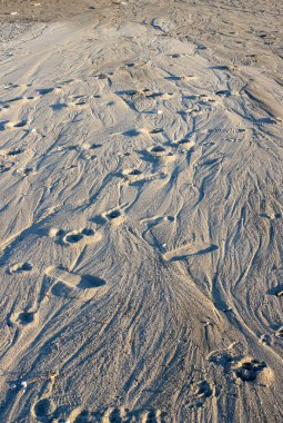 Yüksek gelgit geçtikten sonra yapılar ve kumdaki çeşitli renkler. Akşam güneşi ışığı. Spadafora, Sicilya, İtalya.