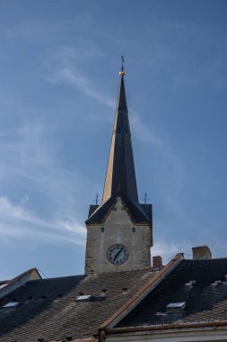 Canterbury 'den Aziz Thomas Kilisesi' nin inşası. Çapraz ve saatli ince kule. Baharda parlak mavi gökyüzü. Mohelnice, Moravya (Morava), Çek Cumhuriyeti.