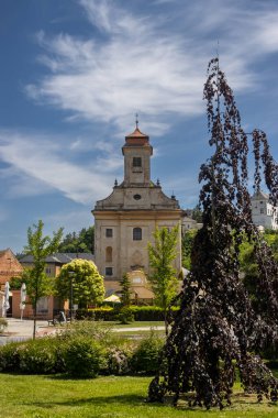Kulesi olan Aziz Jilji kilisesinin yıpranmış eski binası. Etrafta taze yeşillik var. Beyaz bulutlu mavi gökyüzü. Usov, Moravya (Morava), Çek Cumhuriyeti.