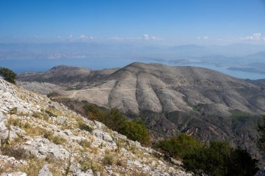 İyonik deniz adasının dağlarındaki Pantokrator 'un bakış açısından bak. Mavi gökyüzü ve ışık bulutları. Korfu (Korfu), Yunanistan.