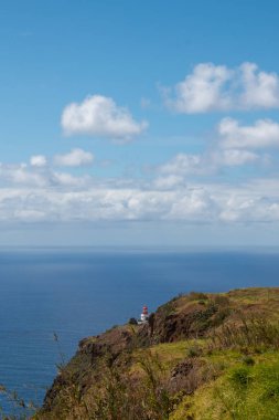 Kayalıklar ve Atlantik Okyanusu. Bahar mevsiminde doğa. Açık beyaz bulutlu mavi gökyüzü. Ponta do Pargo, Madeira, Portekiz.