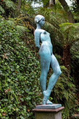 Eski bir kız heykeli. Arka planda taze yeşillik var. Tropik botanik bahçesi Monte Sarayı, Funchal, Madeira, Portekiz.