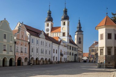 İki kulesi ve Aziz Yakup Kilisesi 'nin kulesi olan İsa' nın Kilisesi. Renkli bir ev. Mavi parlak gökyüzü. Telc, Çek repbulik.