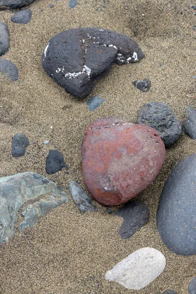 Sarı ve koyu volkanik kumların yapısı soyut dokular yaratıyor, çakıl taşlarıyla birlikte. El Burrero, Las Palmas, Gran Kanarya, Kanarya Adaları, İspanya.