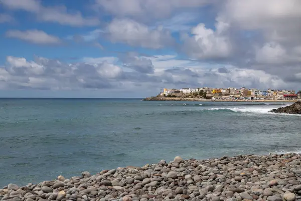 Atlantik Okyanusu 'nun sakin turkuaz suyu. Kışın kumsal bomboş olur. Beyaz bulutlu mavi gökyüzü. El Pajar, Las Palmas, Gran Kanarya, Kanarya Adaları, İspanya.