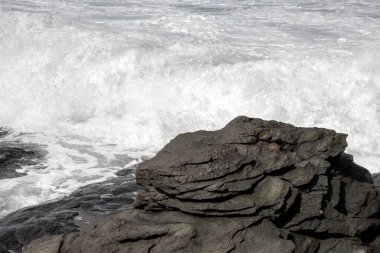 Atlantik Okyanusu kıyısındaki volkanik siyah kayalar. Kış rüzgarlı bir günde yoğun dalgalar. Las Palmas, Gran Canaria, Kanarya Adaları, İspanya.