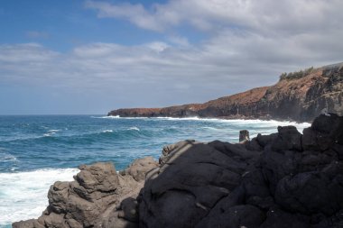 Atlantik Okyanusu 'nun kayalık kıyıları ve rüzgarlı kış günlerinde büyük dalgalar. Arka plandaki dağ. Las Palmas, Gran Canaria, Kanarya Adaları, İspanya.