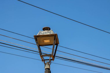 Eski moda bir fener. Bir sürü elektrik kablosu. Arka planda parlak mavi gökyüzü. Ojos de Garza, Las Palmas, Gran Canaria, Kanarya Adaları, İspanya.
