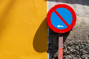 Çember trafik işareti. Okla park edilmez. Arka planda sarı ve doğal bir cephe var. Arucas, Las Palmas, Gran Canaria, Kanarya Adaları, İspanya