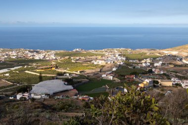 Adanın kuzeyinde bir dağdan (La Montana de Arucas) manzara. Evler ve tepeler. Beyaz bulutlu mavi gökyüzü. Arucas, Las Palmas, Gran Canaria, Kanarya Adaları, İspanya.
